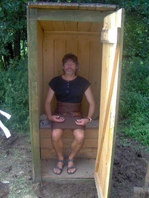 Pán meditující v dřevěné kadibudce