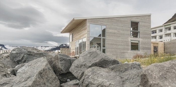 Domek ze světlého dřeva stojí v krásné islandské krajině