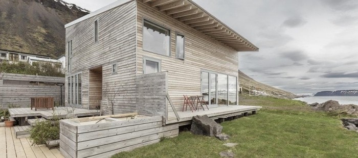 Domek ze světlého dřeva stojí v krásné islandské krajině
